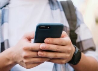 Sådan følger du med i de seneste sportsnyheder fra ind- og udland Mand der tjekker sportsnyheder på sin telefon
